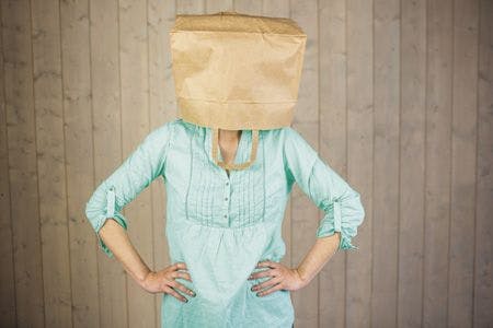 veterinary-woman-covering-head-with-brown-paper-bag-while-standing-against-wall-450px-shutterstock-322224671.jpg